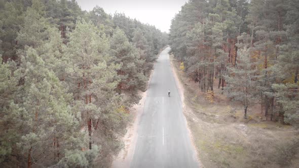 Sport concept. Professional cyclist training on road bicycle on empty car road