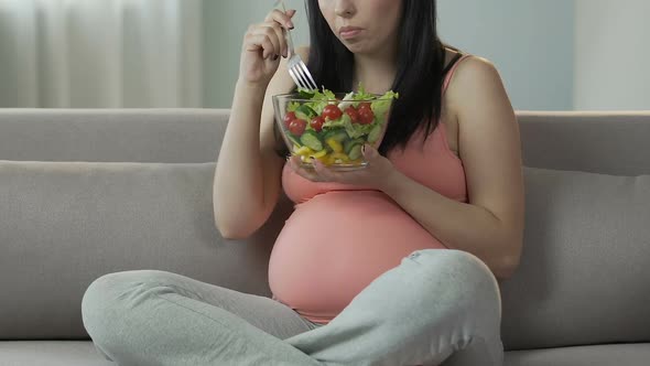 Female Pregnant With Child Sitting on Sofa Eating Salad, Healthy Dieting Balance