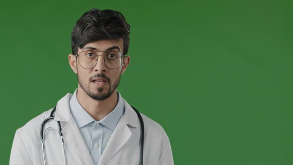 Young Arabian Male Doctor Man Physician in White Medical Uniform on Green Background Consult Remote