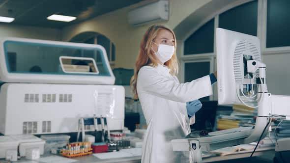 Researcher of Microbiology Working in the Laboratory Presses the Keys of the Touch Screen of the