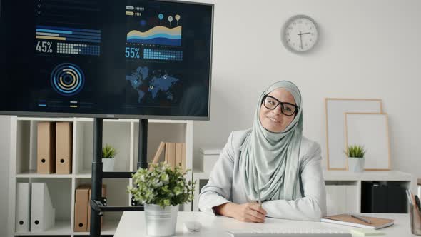 Portrait of Muslim Woman Employee Making Presentation with Digital Screen During Online Video Call