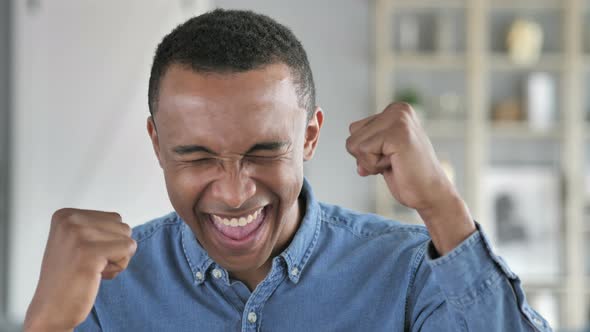 Young African Man Celebrating Success  Gesture in Office
