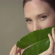 Beautiful young woman with soft and clean skin posing with tropical leaves. - VideoHive Item for Sale