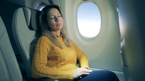 Gorgeous Woman Is Sleeping in the Cabin of the Aircraft