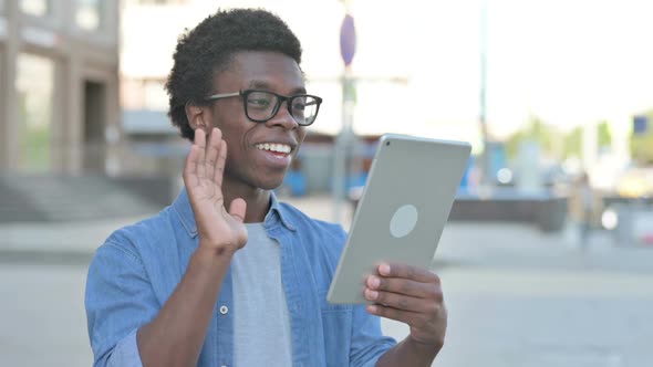 Video Call on Tablet By Young African Man Outdoor