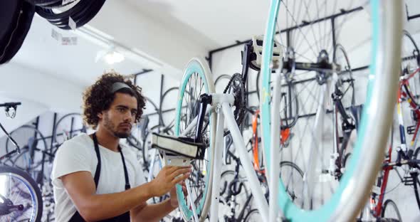 Mechanic repairing bicycle in workshop