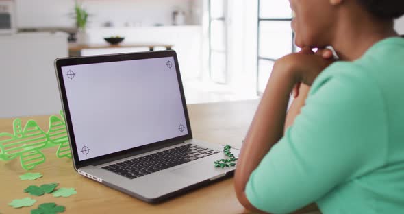 Happy african american woman sitting at table,making video call using laptop with copy space