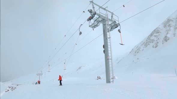 Snowboard Rider on Drag Ski Lift Waves Hello