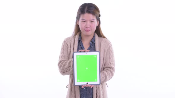 Happy Young Asian Woman Showing Digital Tablet Ready for Winter