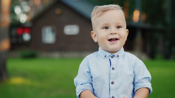 Portrait of a Baby Boy with a Banana. Standing in Front of His House and Smiling