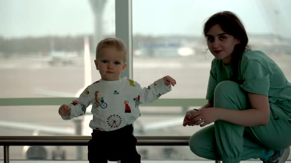 Toddler Boy Running From Mom to Camera in Airport