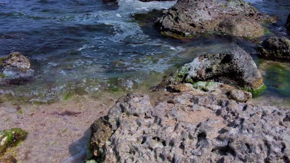 Sunny Beach with Blue Sea Water, Blue Sky and Rocks on the Horizon in a Summer Day, Closeup to Wide