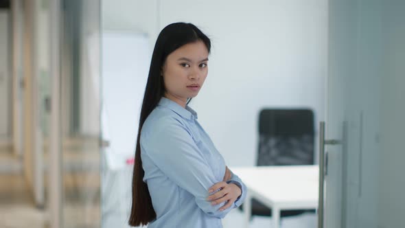 Profile Portrait of Young Professional Business Woman with Folded Arms Posing at Office Looking at