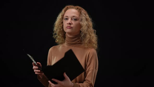 Slim Caucasian Beautiful Woman Turning to Camera with Serious Facial Expression Holding Documents