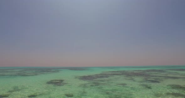 Wide angle birds eye abstract shot of a sunshine white sandy paradise beach and blue ocean backgroun