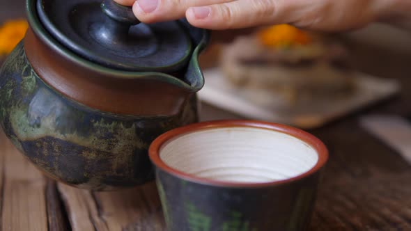 Tea Ceremony. Pouring Black Tea From Tea Kettle To the Mug.
