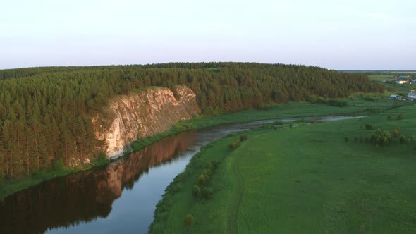 Aerial View of the River with a Rock and Forest on the Banks