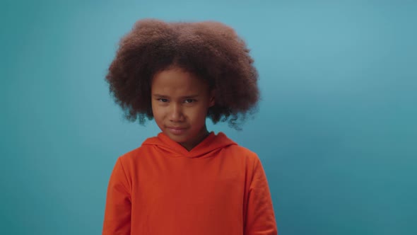 Cute African American girl shaking her head negative saying 'No' standing on blue background.