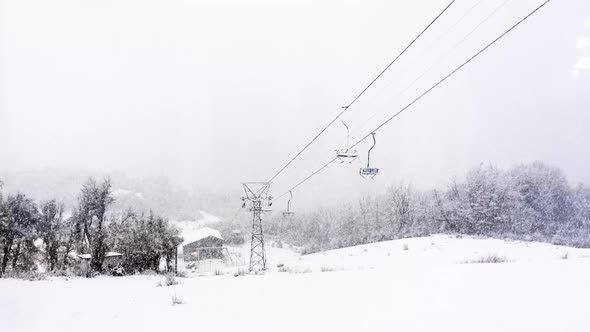 Time lapse video of moving ropeway chairs in a beautiful landscpe covered in snow during winter.