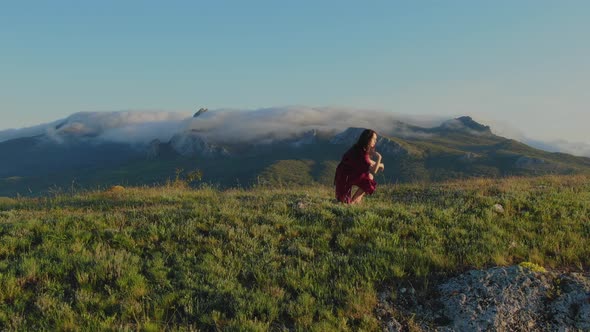 Dance of a Young Woman Barefoot on the Grass in the Rays of the Sunset Against the Background of