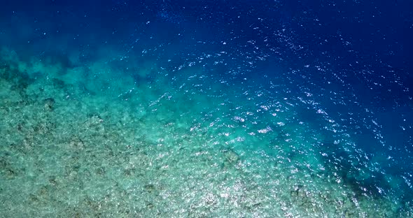 Wide angle above island view of a white paradise beach and blue ocean background in colorful 