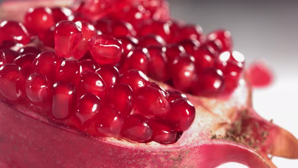 Pomegranate Grains Rolls Down on Surface of Broken Pomegranate in Slow Motion