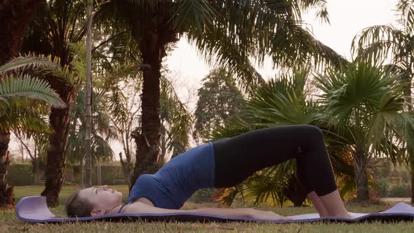 Fitness Woman Making Glute Bridge Workout Exercise on Sports Mat in Park