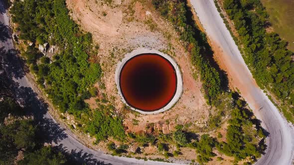 Incredible natural phenomenon in form of sinkhole with brown water in field