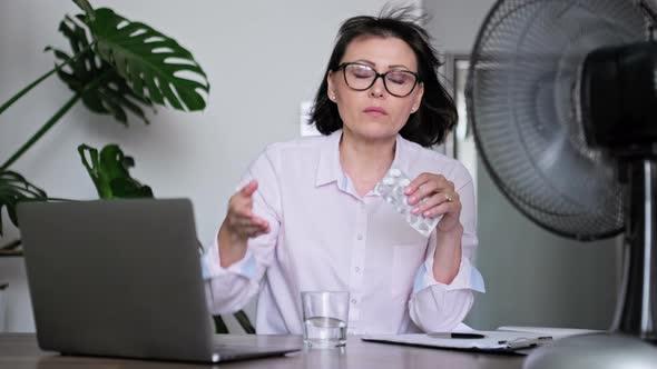 Mature Woman with Glass of Water Blister of Pills Taking Medicine