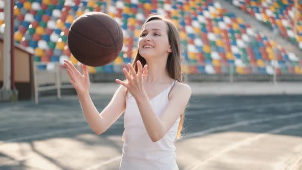 Young Sporty Girl Playing with a Sport Ball at a Stadium