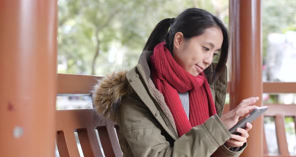 Young asian woman using smart phone in china, beautiful chinese pavilion garden