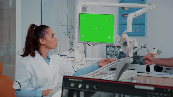 Woman Analyzing Green Screen on Monitor and Teeth x Ray