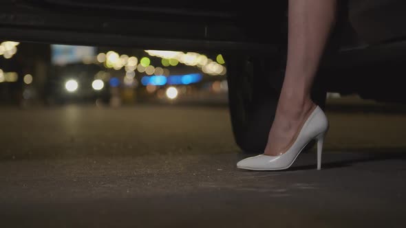 Slim Female Legs in High Heels Exit Car at Night