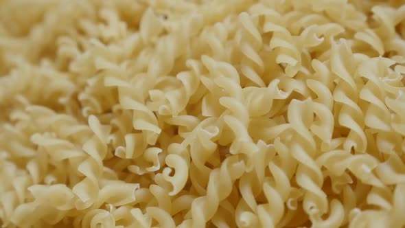 Slow motion corkscrew shaped pasta pile fall on table close-up 1920X1080 HD footage -  Falling on to