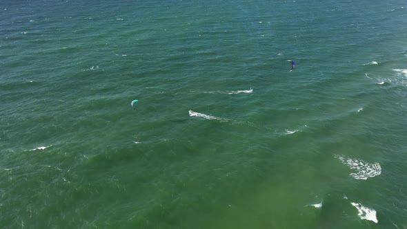 AERIAL: Locked Shot of Surfers in Green Baltic Sea on Perfect Sunny Weather in Natural Daylight