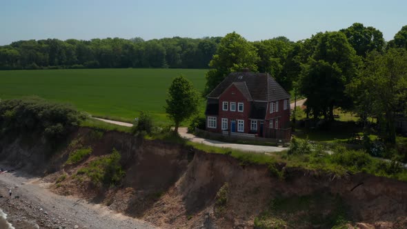 Aerial Drone Circling Around Beautiful Wooden Red House Facing Baltic Sea in Brodten Germany Drone