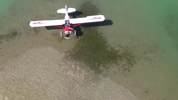 Airplane about to land on a short beach in the remote wilderness.