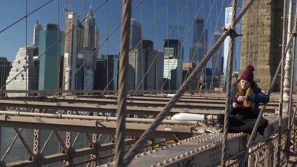 Beautiful Girl on Brooklyn Bridge Enjoys a Sunny Day While Relaxing