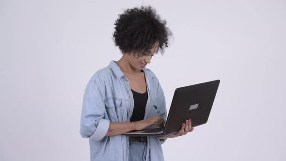 Young Happy African Woman Thinking While Using Laptop