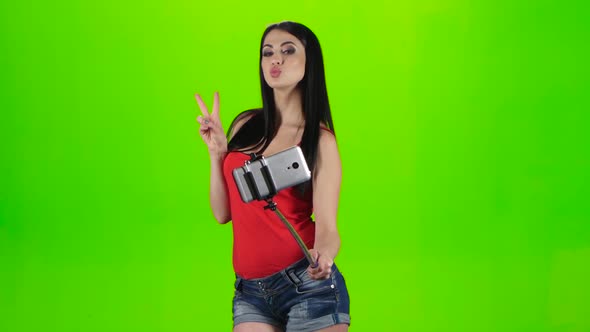 Girl Doing Selfie Using a Smartphone Fixed on the Monopod