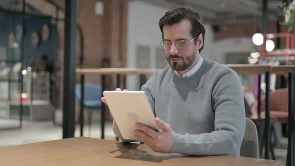Young Man Using Tablet While Sitting in Office