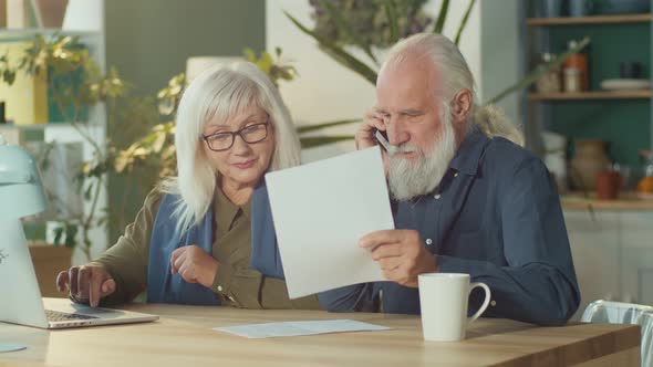 A Worried Elderly Couple Discussing Unpaid Bank Debt Checking Expenses