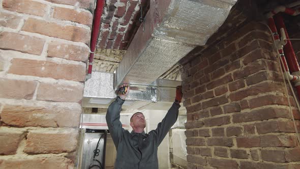 The Master Carries Out Measurements of Ventilating Channels on Construction. The Employee Measures