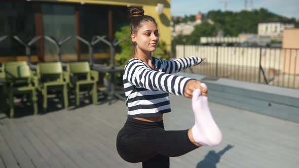 Woman Doing Yoga Exercises on House Roof in Early Morning