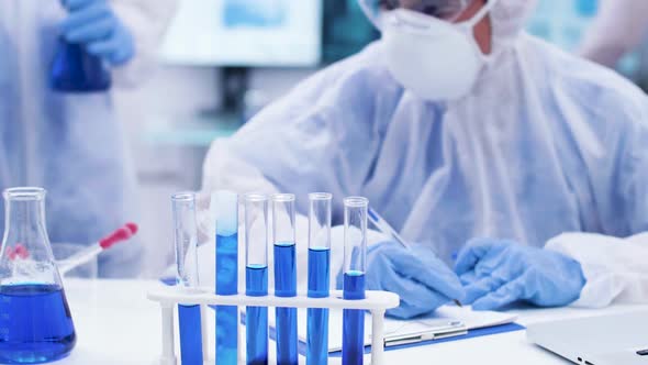 Scientist Colleague Adding Solution with Pipette on Smoking Blue Fluid