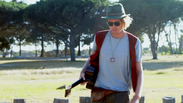 Man holding guitar walking at festival 4k