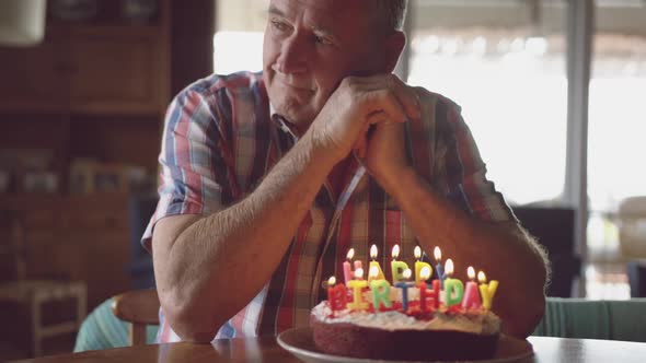 Senior man with a birthday cake at home