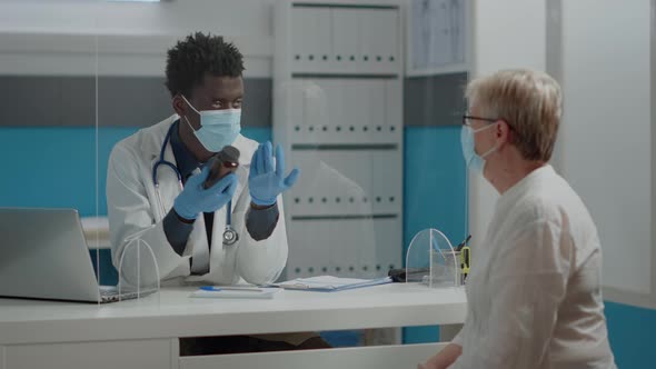 Young Medic Showing Bottle of Pills to Elder Patient