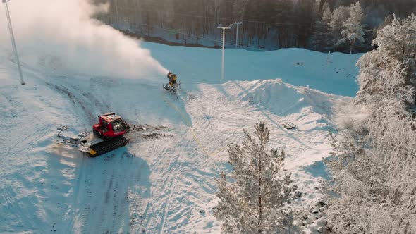 Aerial View Snow Cannon Stands on a Snowy Mountain in the Winter and Works By Producing a Column