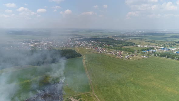 Aerial view of Fire in the field, near a forest and a village 11
